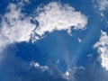 Photo of the sun shining through the clouds against a blue sky background Royalty Free Stock Photo