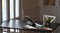 Photo of sunlight shining through the window to black working desk. Computer tablet, notebook, potted plant and coffee cup. Royalty Free Stock Photo