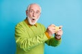 Photo of surprised grandfather hold telephone amazed face wear eyeglasses green sweater isolated blue color background