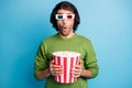 Photo of surprised guy hold popcorn paper bucket shocked face wear 3d glasses green sweater isolated blue color