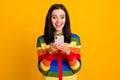 Photo of surprised shocked young girl chat mobile cellphone news isolated over yellow color background