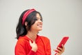 Photo of surprised young woman with bright makeup using smartphone isolated over gray background