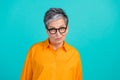 Photo of suspicious distrustful business woman old grandmother raise eyebrows wear orange shirt isolated on aquamarine Royalty Free Stock Photo