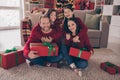 Photo of sweet adorable son daughter dad mom wear red pullovers smiling hugging holding christmas presents indoors house Royalty Free Stock Photo