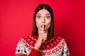 Photo of sweet adorable young lady wear print sweater finger lips asking keep secret isolated red color background