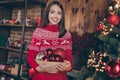 Photo of sweet beautiful young woman dressed red sweater decorating new year tree smiling indoors room home house