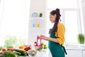 Photo of sweet charming dark skin woman dressed yellow shirt cooking stir salad smiling indoors house home room Royalty Free Stock Photo