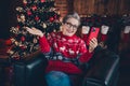 Photo of sweet charming lady dressed red print x-mas pullover spectacles getting new year video greetings modern gadget Royalty Free Stock Photo