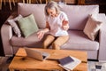 Photo of sweet charming lady pensioner wear white t-shirt sitting sofa smiling having video call modern gadget indoors Royalty Free Stock Photo