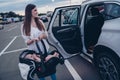 Photo of sweet cheerful mom small daughter wear casual outfits open door putting car seat inside automobile vehicle Royalty Free Stock Photo