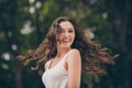 Photo of sweet cute young woman smiling have long curly brunette hair walking park wear white top outdoors Royalty Free Stock Photo