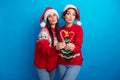 Photo of sweet flirty women santa elf wear ornament pullovers holding x-mas candies sending kiss isolated blue color Royalty Free Stock Photo