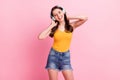 Photo of sweet funny young woman wear yellow singlet listening music arms neck isolated pink color background Royalty Free Stock Photo