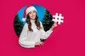 Photo of sweet girl dressed santa claus helper x-mas hat showing hash tag breakthrough paper hole empty space isolated Royalty Free Stock Photo