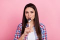 Photo of sweet hungry woman wear plaid shirt licking spoon smiling isolated pink color background