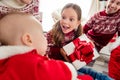 Photo of sweet impressed big family dressed new year pullovers smiling getting gifts indoors house home room