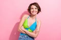 Photo of sweet shiny girl dressed blue green singlet arms crossed smiling isolated pink color background
