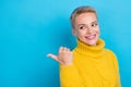 Photo of sweet shiny girl dressed knitwear pullover looking pointing thumb back empty space isolated blue color