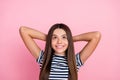 Photo of sweet shiny girl dressed striped clothes arms behind head looking empty space isolated pink color background Royalty Free Stock Photo