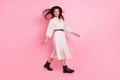 Photo of sweet shiny young lady wear white outfit cap walking wind blowing isolated pink color background