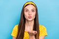 Photo of sweet shiny young woman wear dotted outfit sending arm kiss blue color background