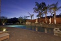 Swimming pool under lights in evening of luxury mansion Royalty Free Stock Photo