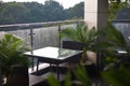 Photo of the table and two chairs on a cozy balcony with view on the rainy nature