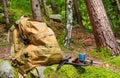 Tactical backpack with flashlight and knife laying on forest rocks