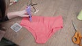 Shooting of tailor gluing pastes on pink woman& x27;s panties