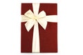 A photo taken on a bright red gift Box bind by a white beige ribbon bow