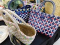 A bunch of colorful handmade straw tote bags on display