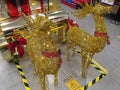 A Christmas decoration of a pair of golden reindeers pulling a golden sleigh