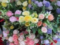 A closeup cluster of very colorful artificial flowers on display for sale