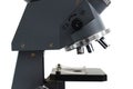 A close up side view of a laboratory multiple high magnification microscope toy replica against a white backdrop