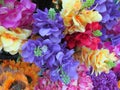 A cluster of assorted artificial fake colorful vibrant flowers on display