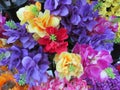 A cluster of very colorful artificial fake flowers on display