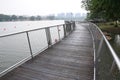 A curving row of boardwalk on a lake with buildings in the backdrop