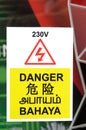 A danger high voltage warning sign in four languages on display