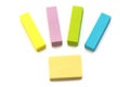 A few bright fluorescent colored self adhesive paper memo pads white backdrop