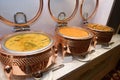 A few dishes of Paneer Makhani and mixed vegetables on heating pots kept warm