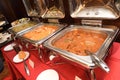A few Indian fried meat dishes with curry gravy sauce on heating trays