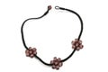 A flower beads patterned black light pink necklace white backdrop