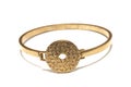 A golden brass bronze bracelet bangle with a patterned disc