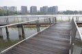 The intersection of two rows of boardwalks on a lake with buildings backdrop