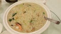 A large bowl serving of asian prawn noodles on a table