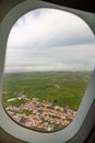 Photo taken out the window of plane, view over island with fields and clouds Royalty Free Stock Photo