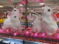 A pair of identical white rabbits replica decorations on display at a supermarket