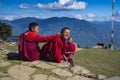 Two cute Bhutanese novice young monks on the mountain top , one turns his head and smiles