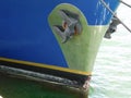 The retracted anchor at the hull of a boat ship vessel docked at sea