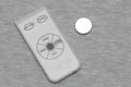 Small white and grey remote controller and a button cell coin lithium battery